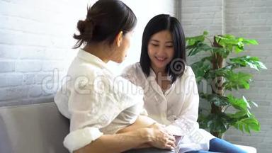 亚洲年轻孕妇在医院产前班与另一名孕妇交谈